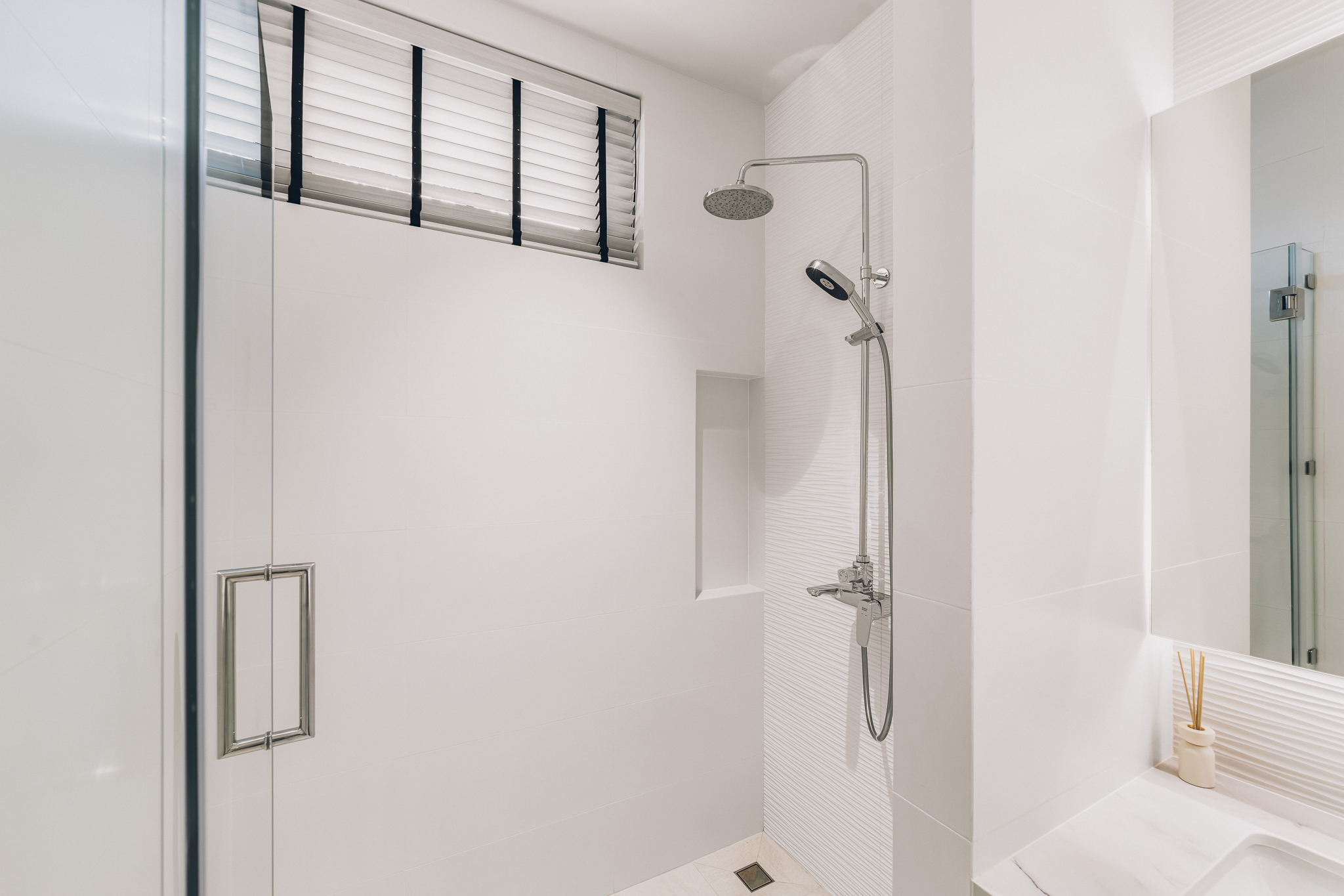 Polished Chrome Faucet Profile — Architectural profile of the basin mixer against sculpted white ceramic wall tiles (Photo #29)